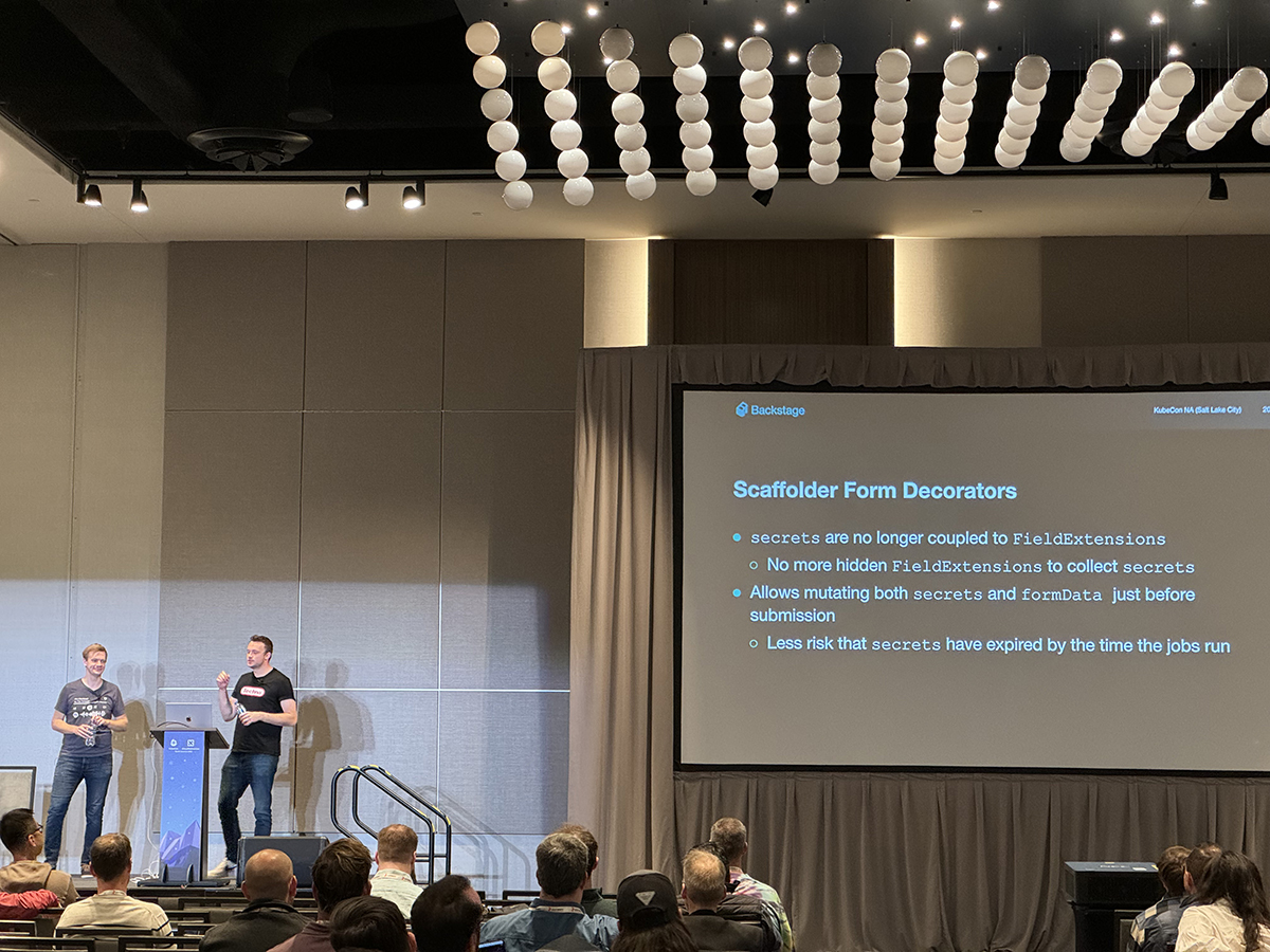 Backstage maintainers presenting in a ballroom